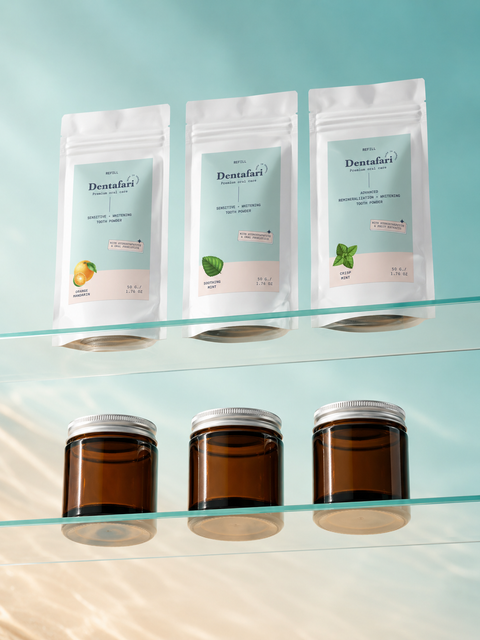 Drei Dentafari Zahnpulver-Refills und Braunglas-Tiegel mit Aluminiumdeckel im Regal – nachhaltige Verpackung